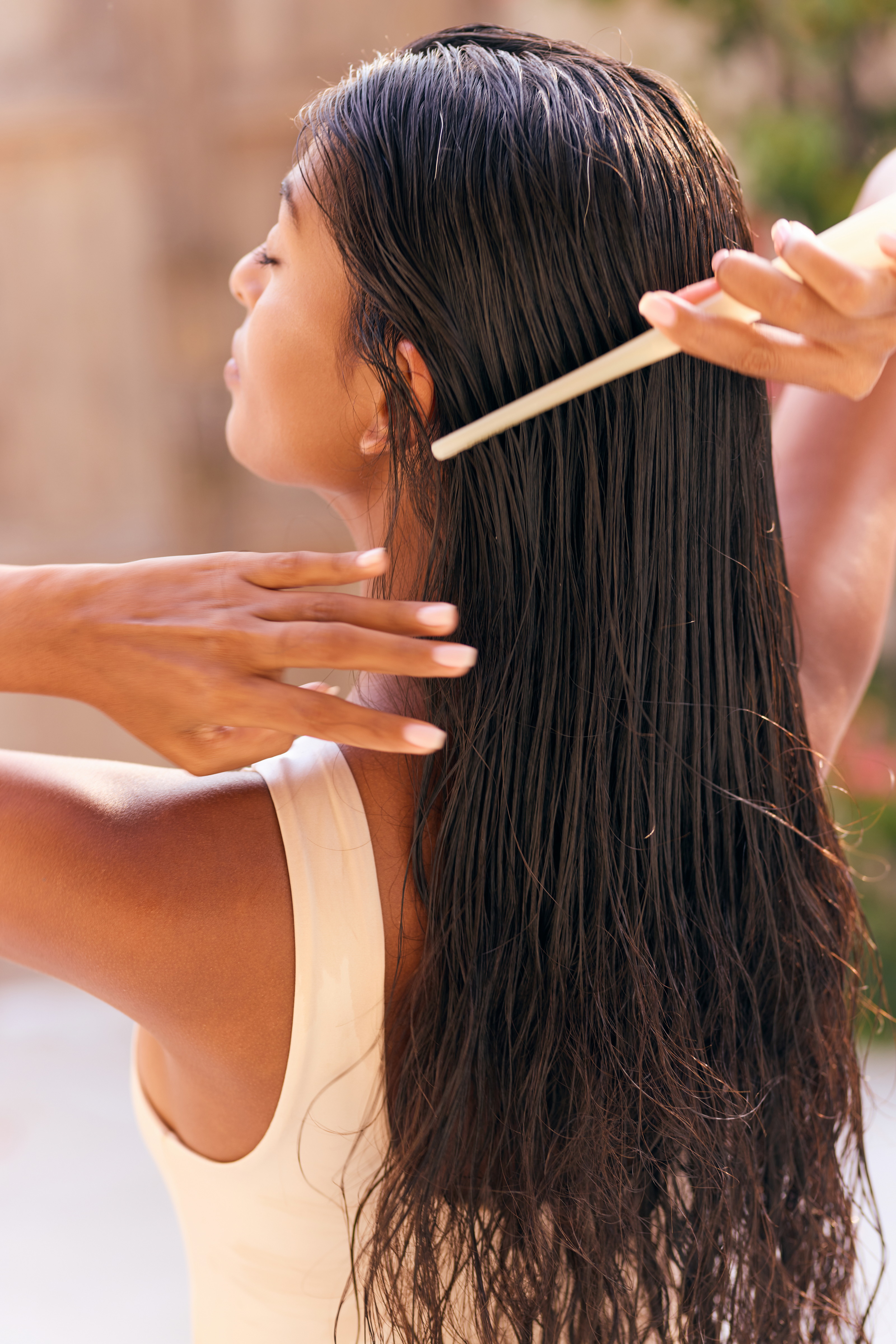 Woman combing her long wet hair as part of an Ayurvedic hair care routine