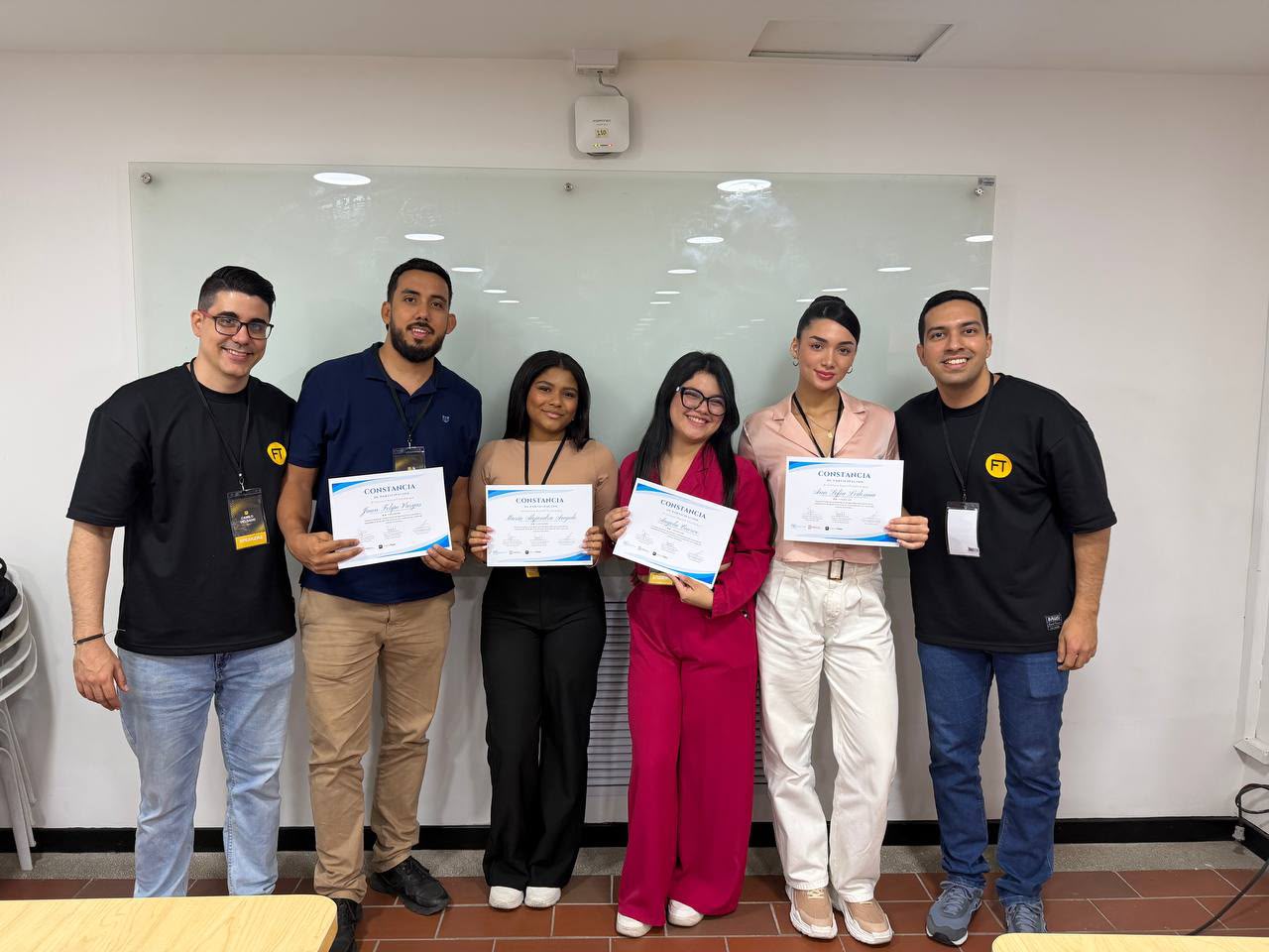 Estudiantes del Trading Lab de la USB Cali muestran sus constancias de participación, junto a instructores de FinancialTools.io.