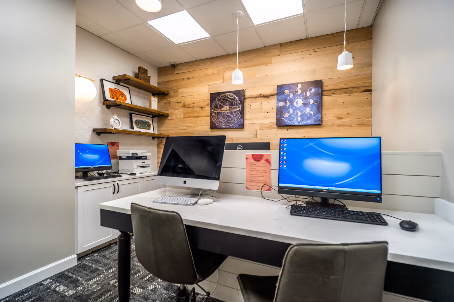 Resident business center and computer lab with multiple workstations and a modern, wood-plank accent wall at Rev Oxford in Oxford, MS.