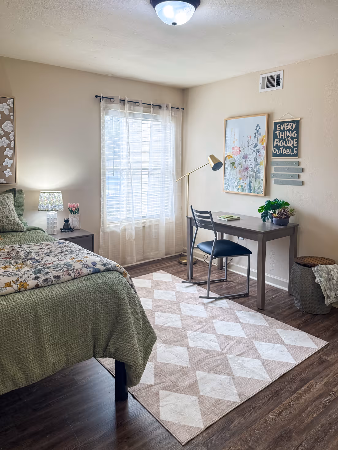 Student apartment bedroom with a bed, desk, featuring a vibrant modern wall art at Rev Oxford in Oxford, MS.