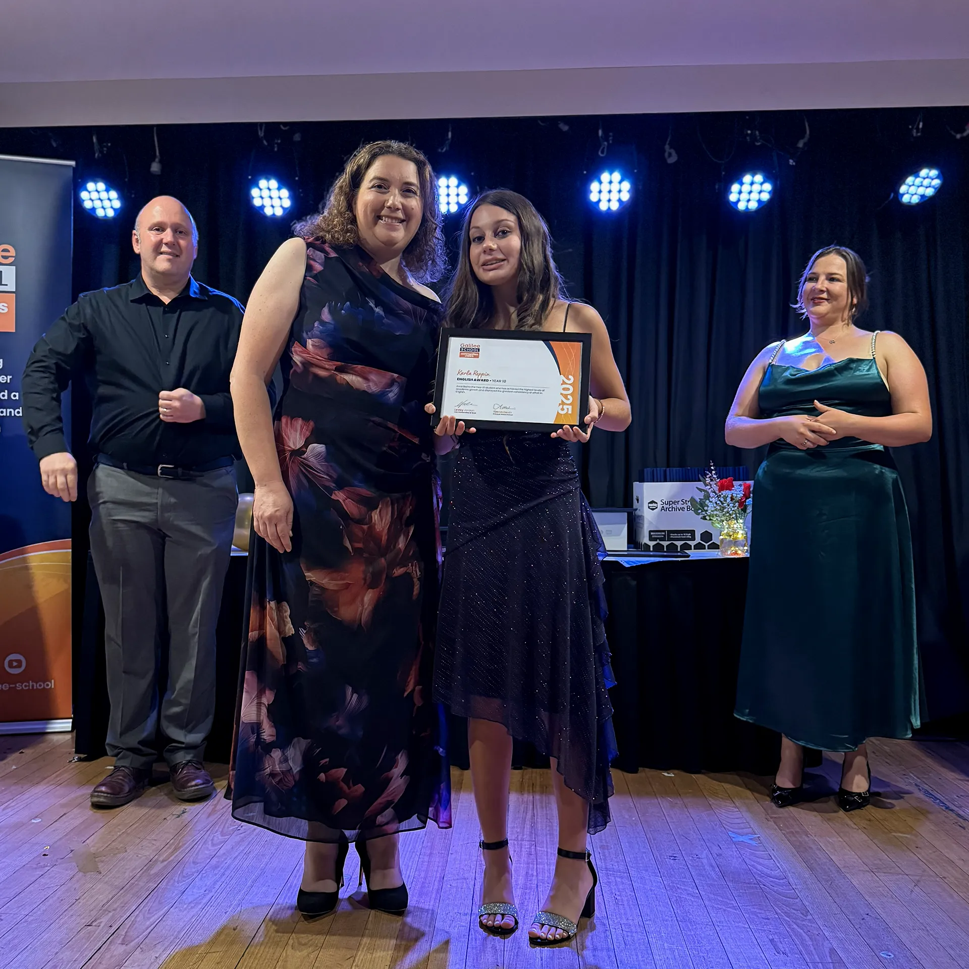 Teacher with student holding graduation certificate.