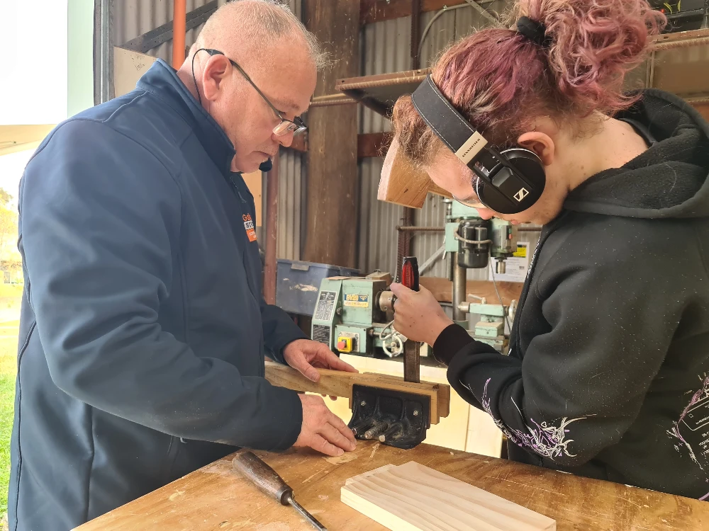 Student and teacher working on a woodwork project. 
