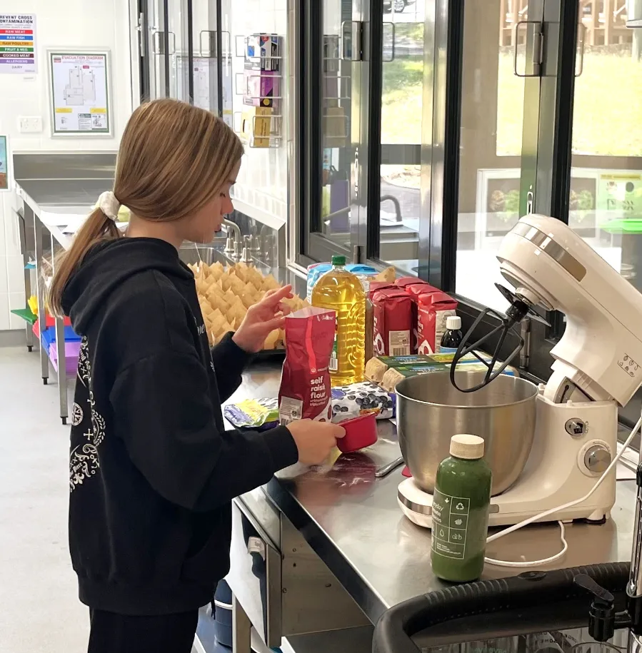 Student mixing batter for muffins. 
