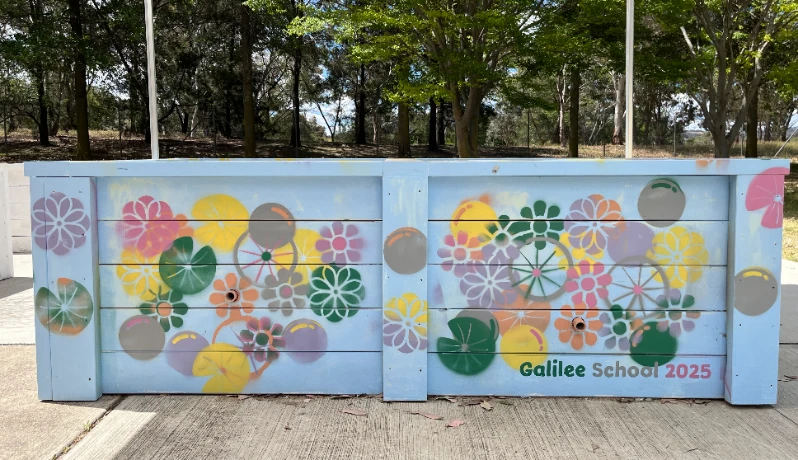 Blue mural artwork with an abstract pastel coloured floral pattern.