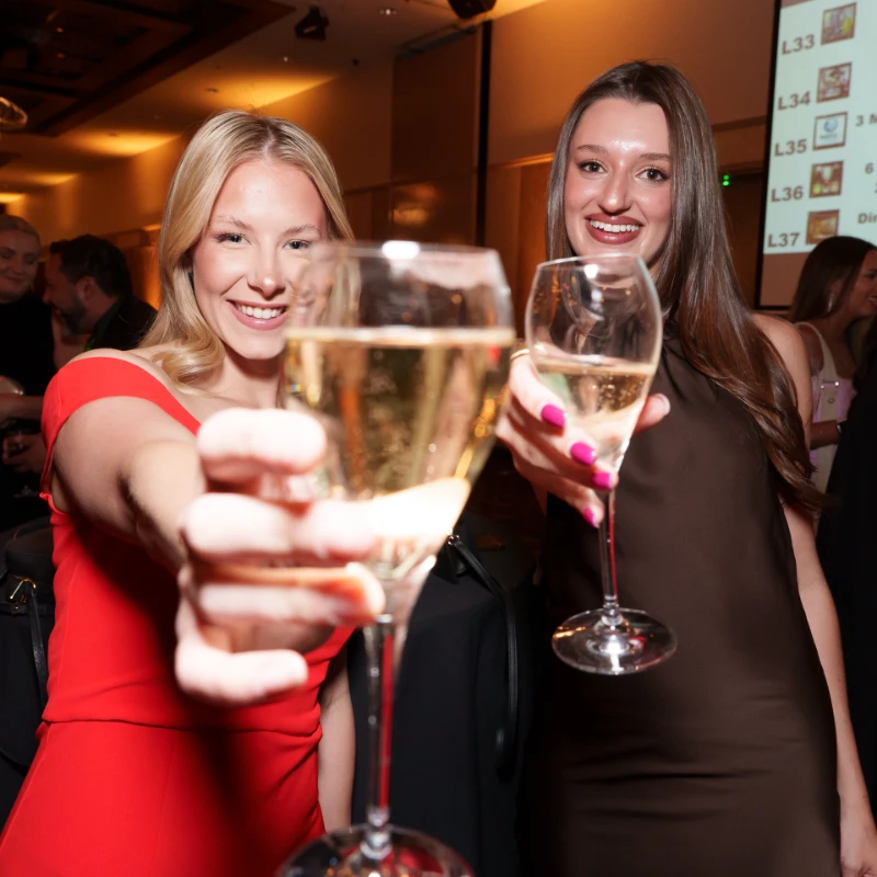 Two women holding wine glasses and smiling.