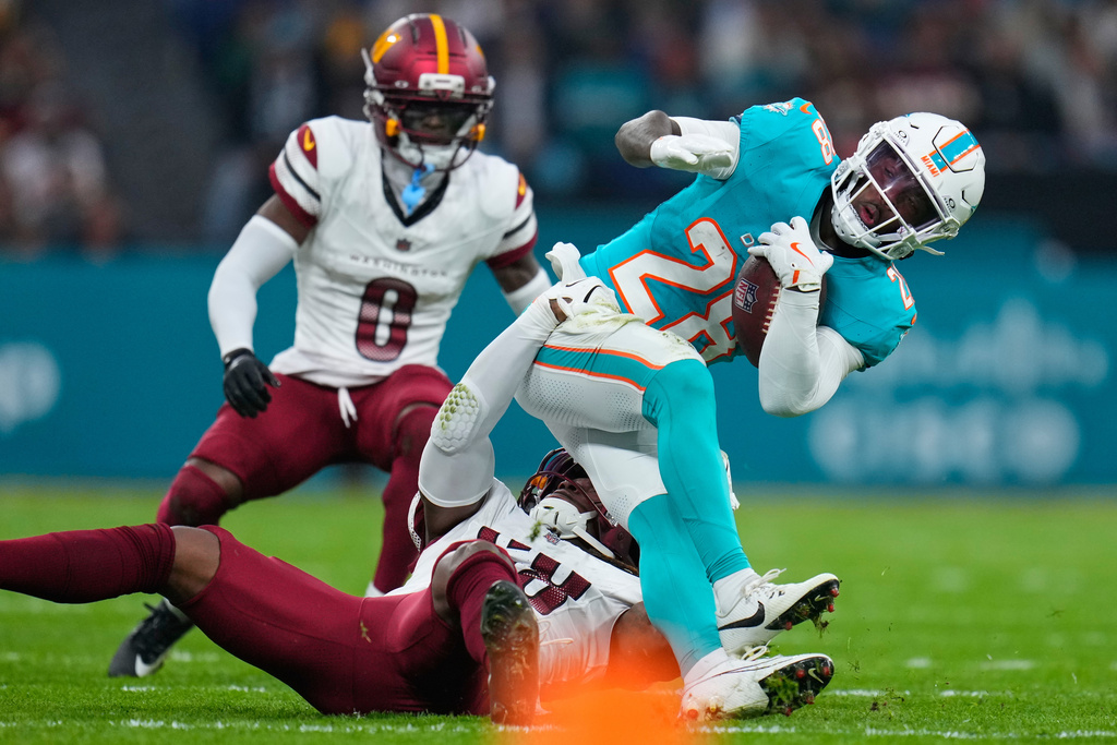 Dolphins RB De'Von Achane is tackled in an NFL football game.