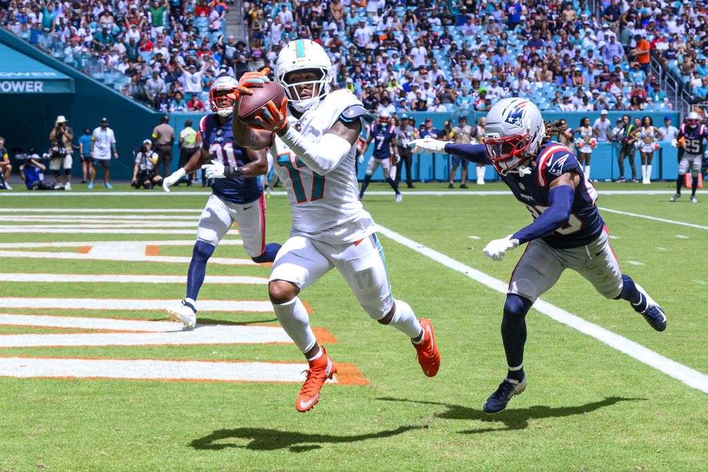 Dolphins WR Jaylen Waddle catches a football in an NFL game.