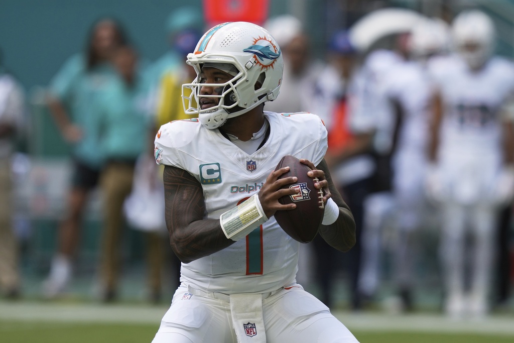 Dolphins QB Tua Tagovailoa throws a football in an NFL game.
