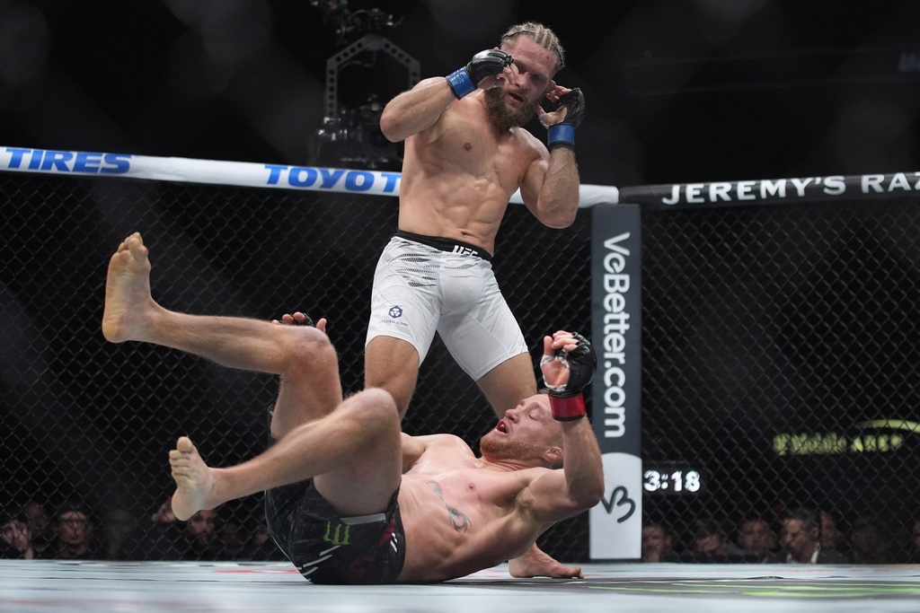 Rafael Fiziev knocks down Justin Gaethje during a UFC 313 lightweight fight.