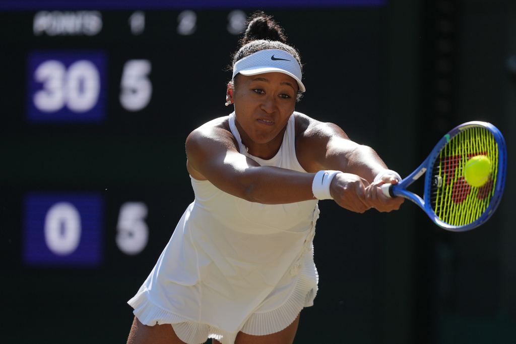 Tennis star Naomi Osaka of Japan hits a return shot during the Wimbledon quarterfinals.