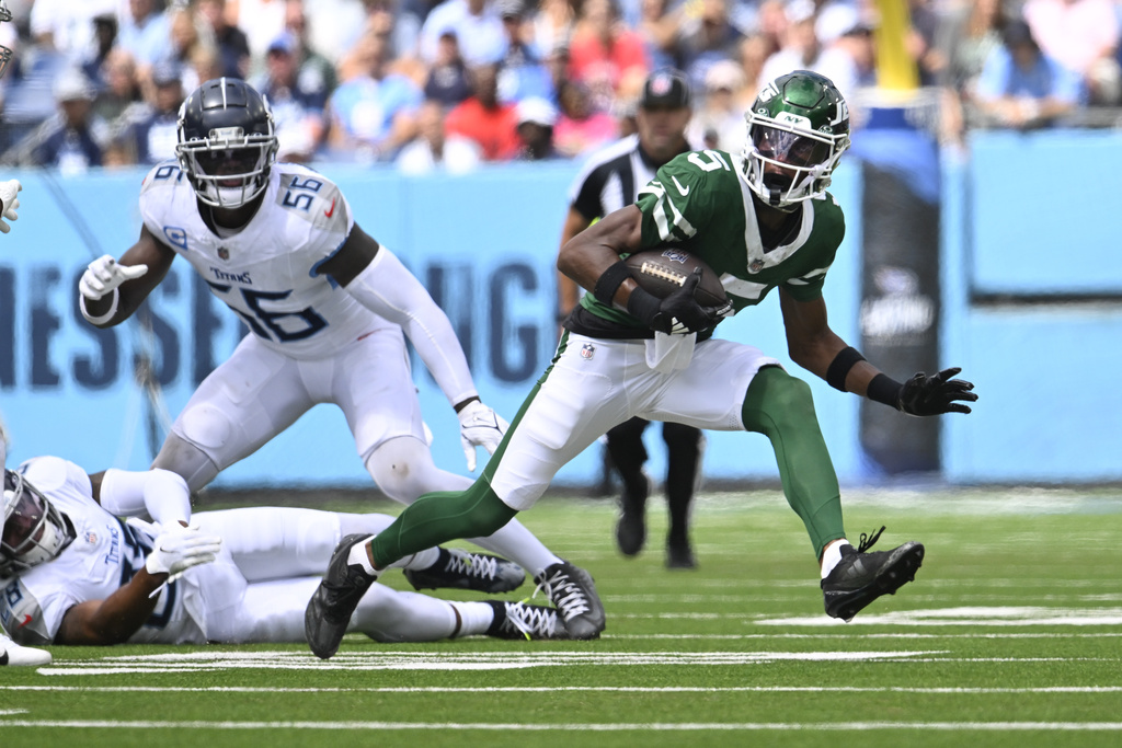 New York Jets wide receiver Garrett Wilson (5) runs as Tennessee Titans linebacker Kenneth Murray Jr. (56) and safety Quandre Diggs (28) defend during an NFL football game Sunday, Sept. 15, 2024, in Nashville, Tenn.