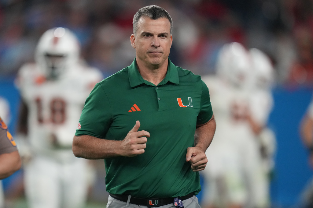 Miami Hurricanes HC Mario Cristobal runs out during a Fiesta Bowl game against Ole Miss.