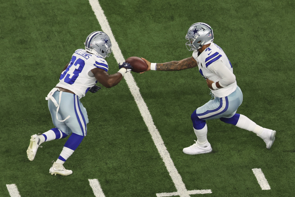 Dallas Cowboys RB Javonte Williams receives a handoff from QB Dak Prescott during an NFL game.