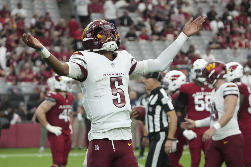 Commanders QB Jayden Daniels celebrates a touchdown vs. the Cardinals.
