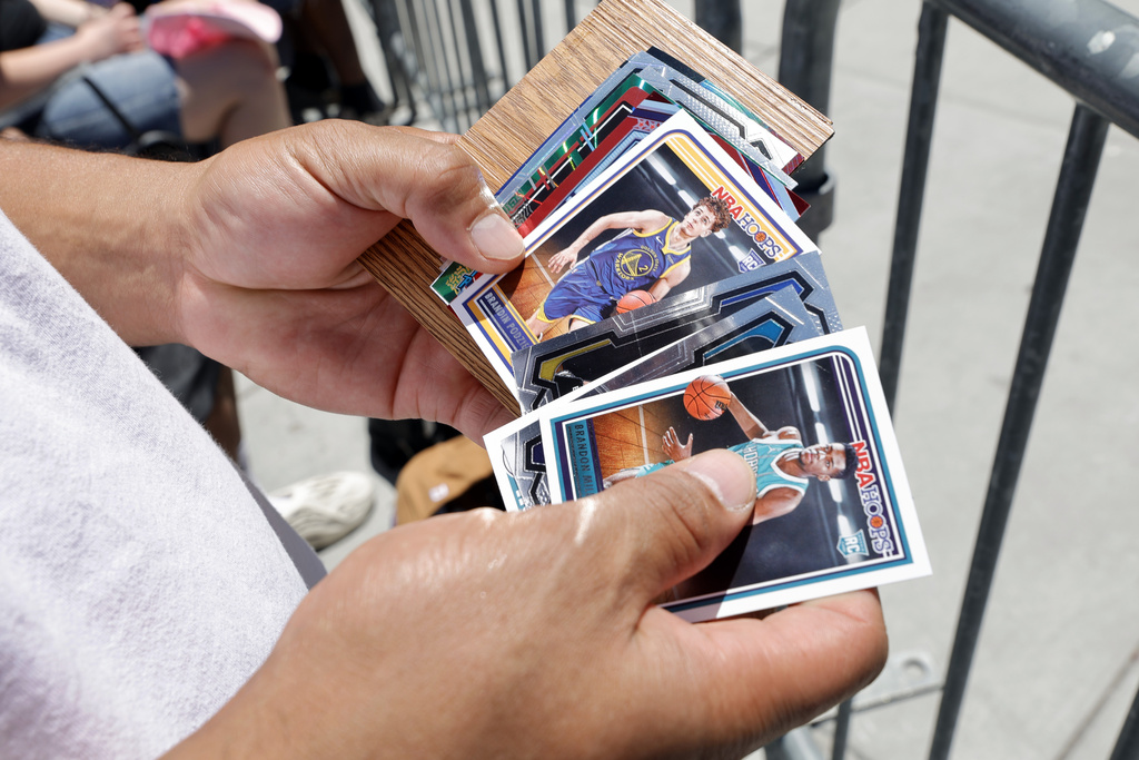Autograph seeker Joe Ortiz, of Las Vegas, displays NBA trading cards as he waits for United States men's basketball team players to arrive for training camp Saturday, July 6, 2024, in Las Vegas.