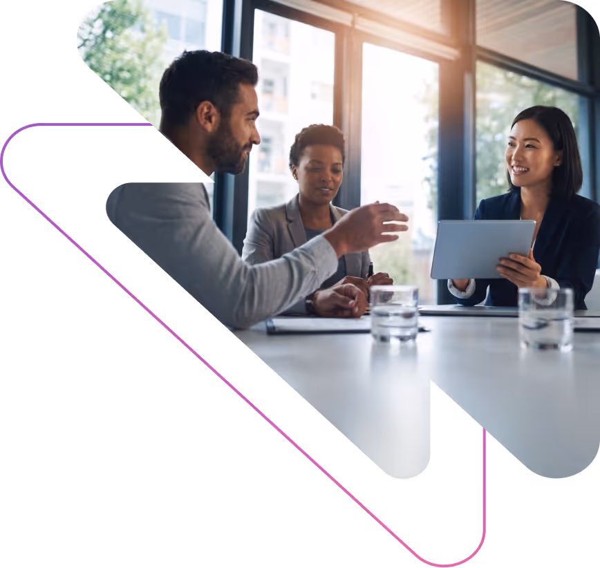Three diverse business professionals having a meeting in a bright office, with one woman holding a tablet.