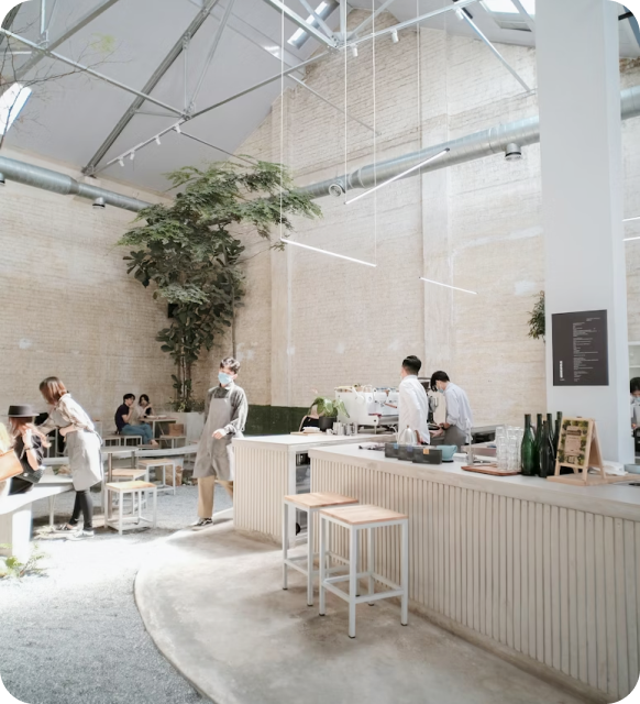 Bright modern coffee shop interior with customers and staff, overlaid with a world map highlighting different coffee shop locations.