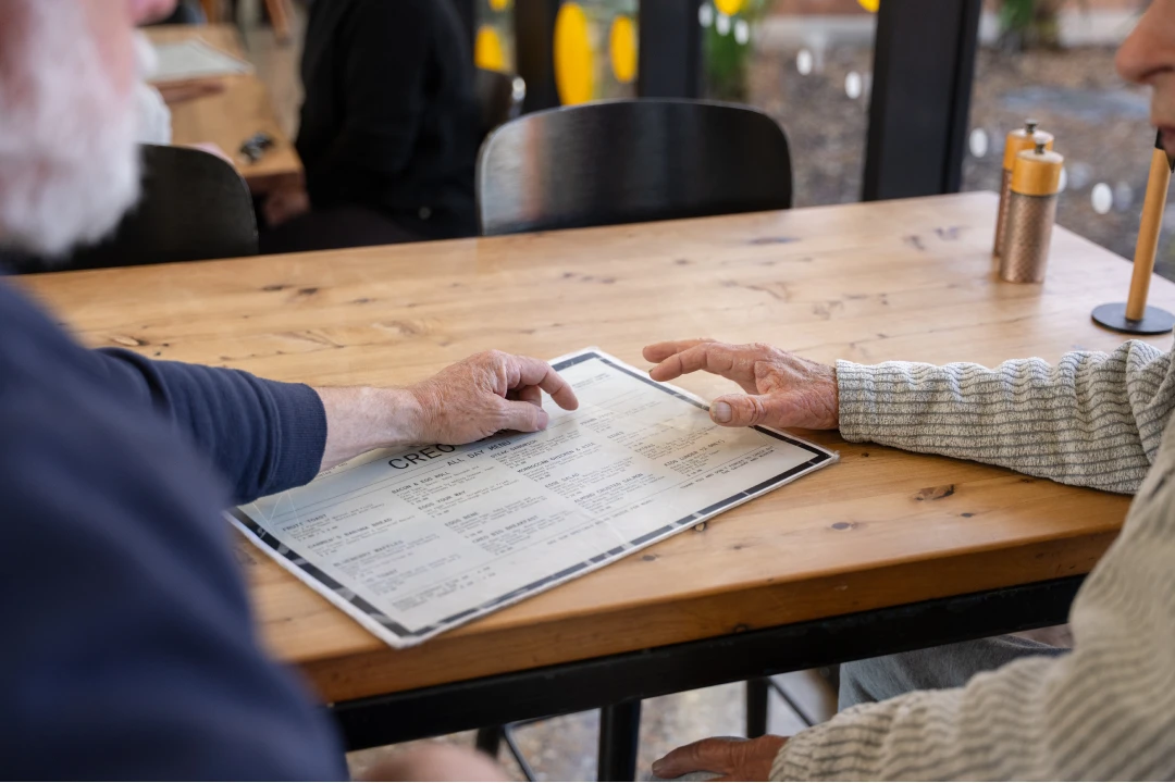 Care worker and older adult reviewing a menu together