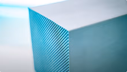 Gros plan sur un coin d'un appareil électronique bleu avec une grille perforée.