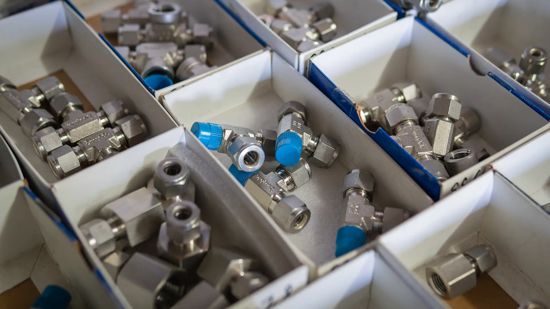 Stainless steel fittings and spare parts sorted in storage trays