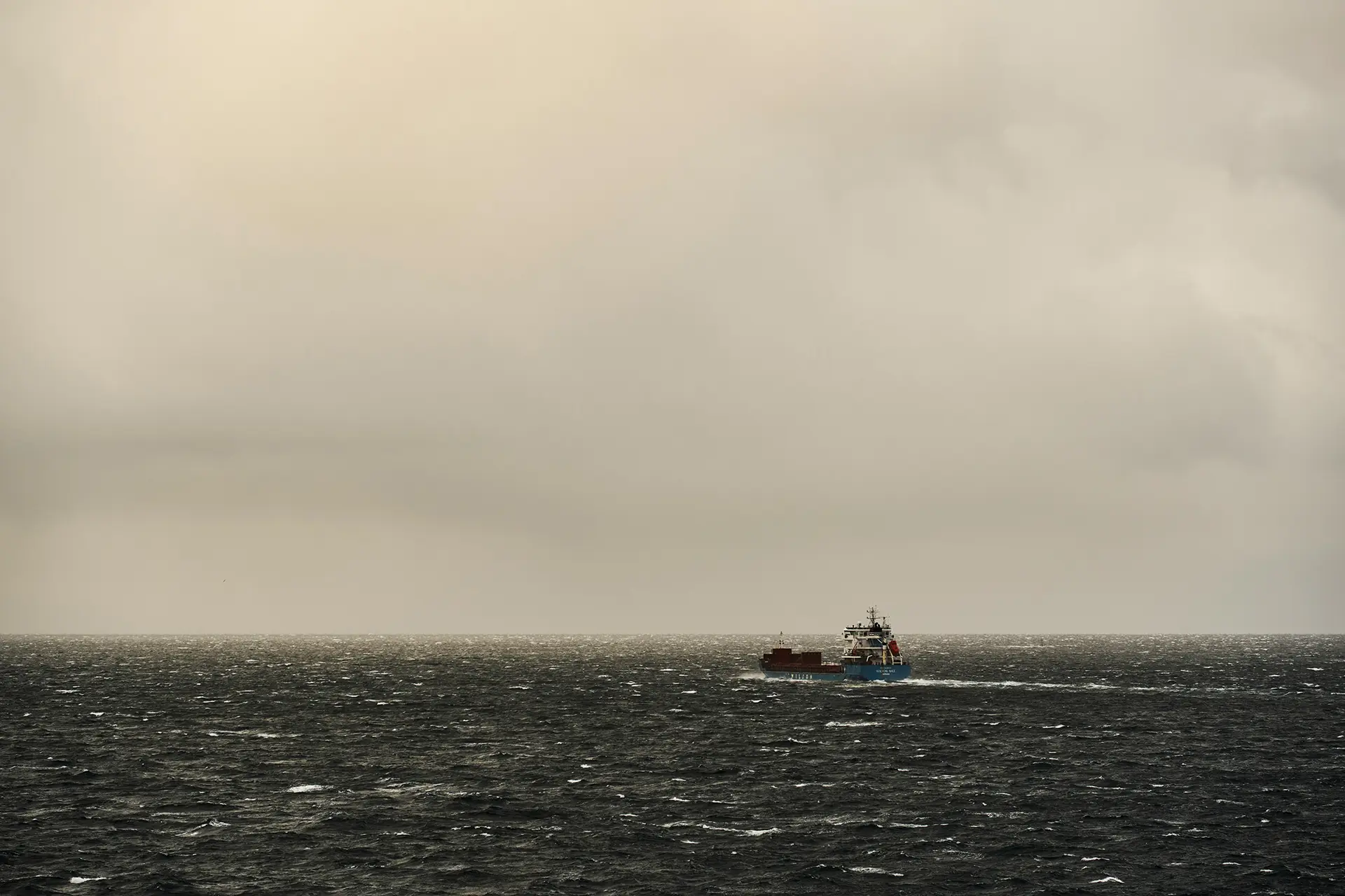 Vessel at sea under heavy grey skies