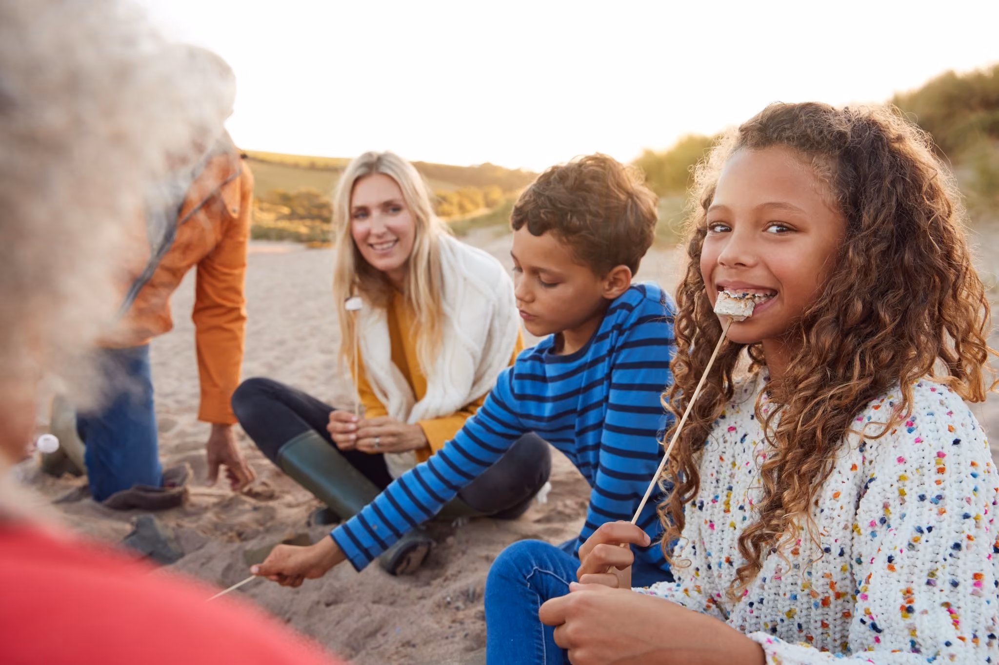 portrait-of-multi-generation-family-toasting-marshmallow