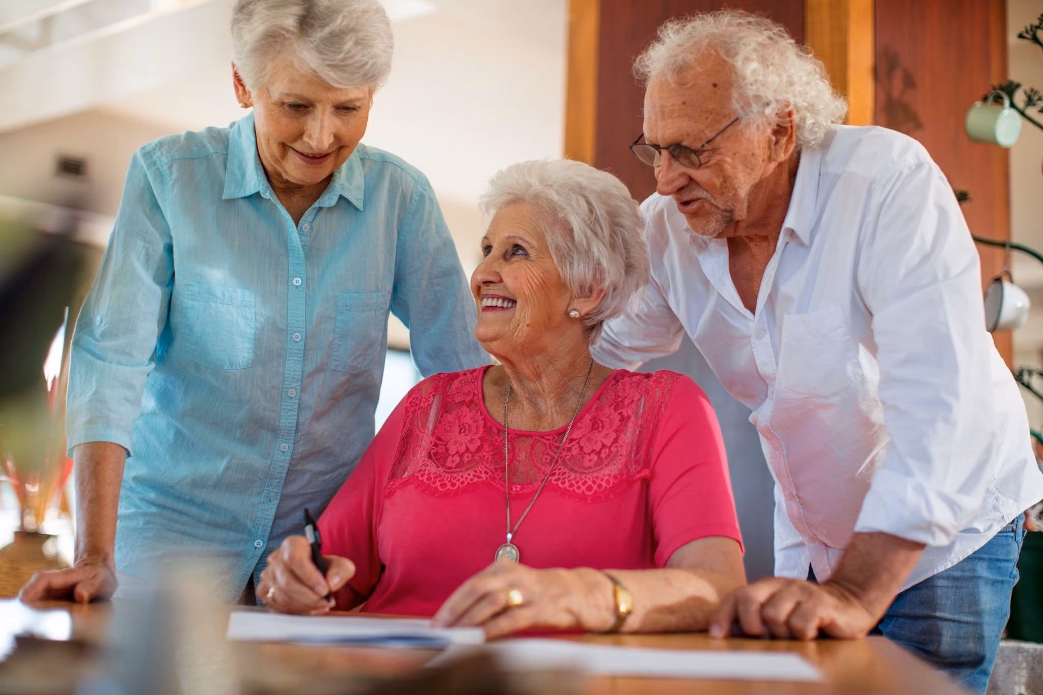 senior woman signing a contract with friends