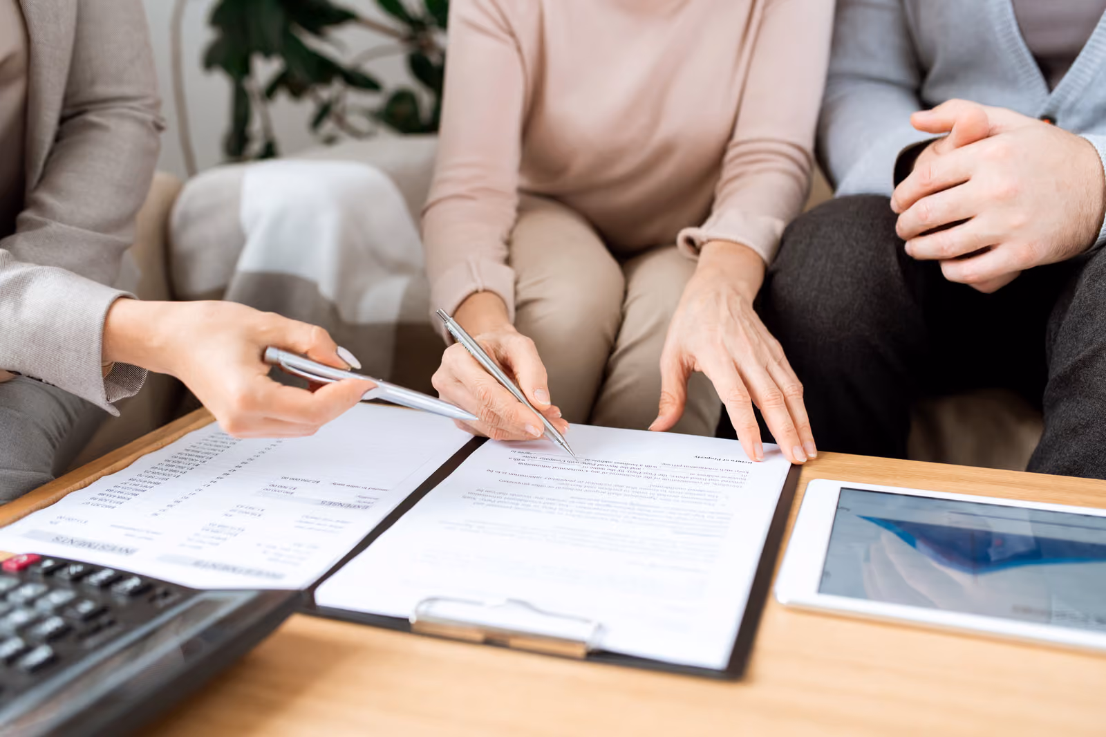 Couple reviewing and signing estate planning documents with advisor