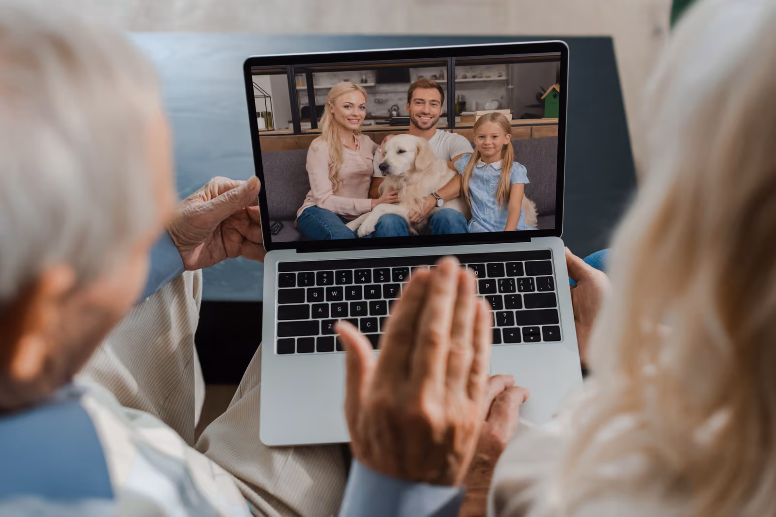 Older couple viewing family photo on laptop, representing digital memories and legacy access