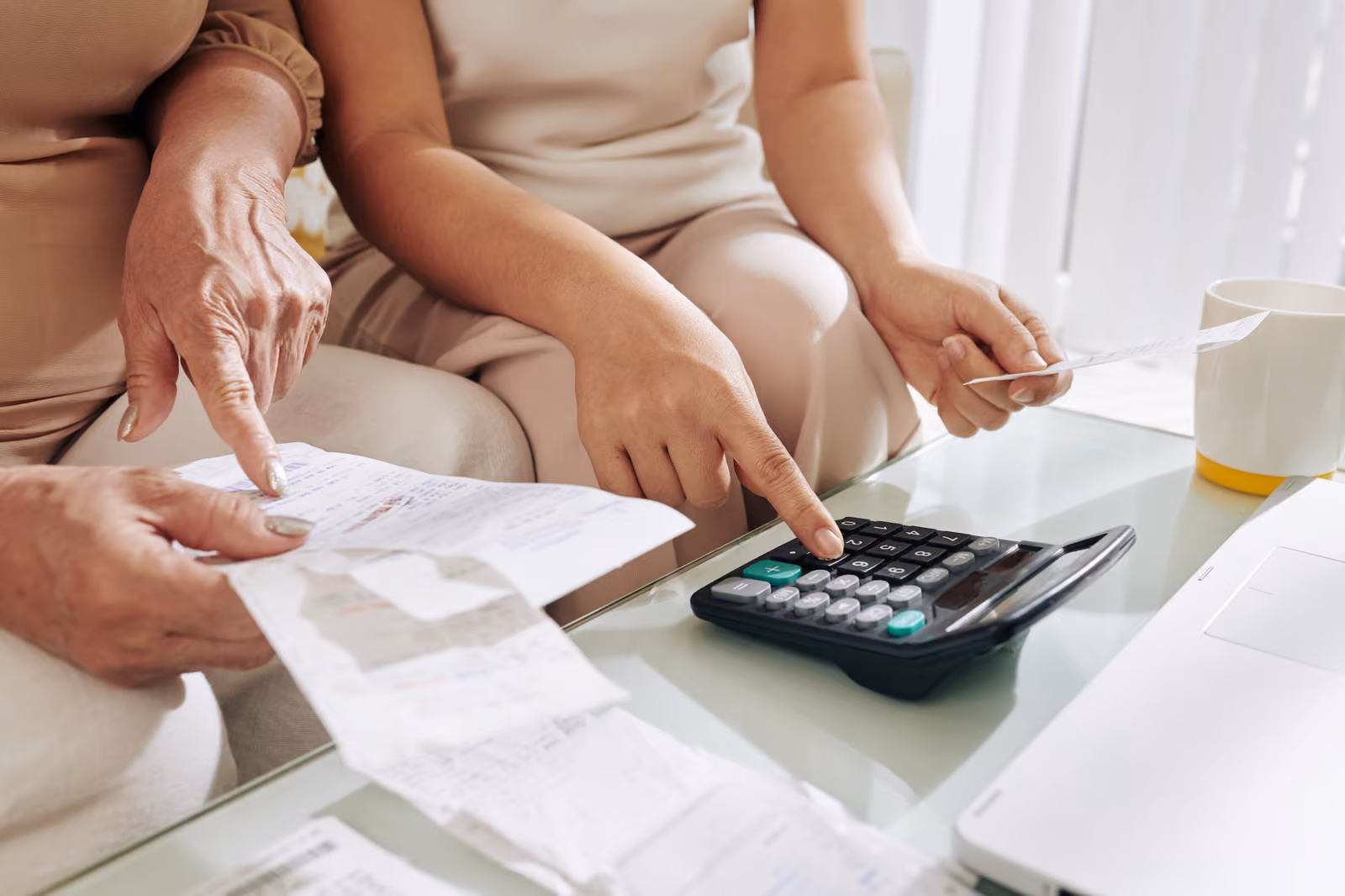 People reviewing bills and using a calculator