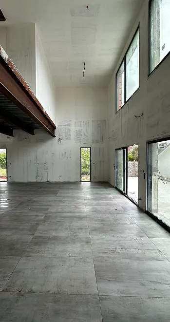 Intérieur d'une maison neuve avec double hauteur et carrelage grand format