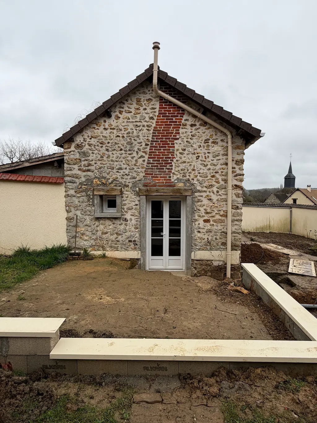 Maison en pierre rénovée avec terrasse en parpaings