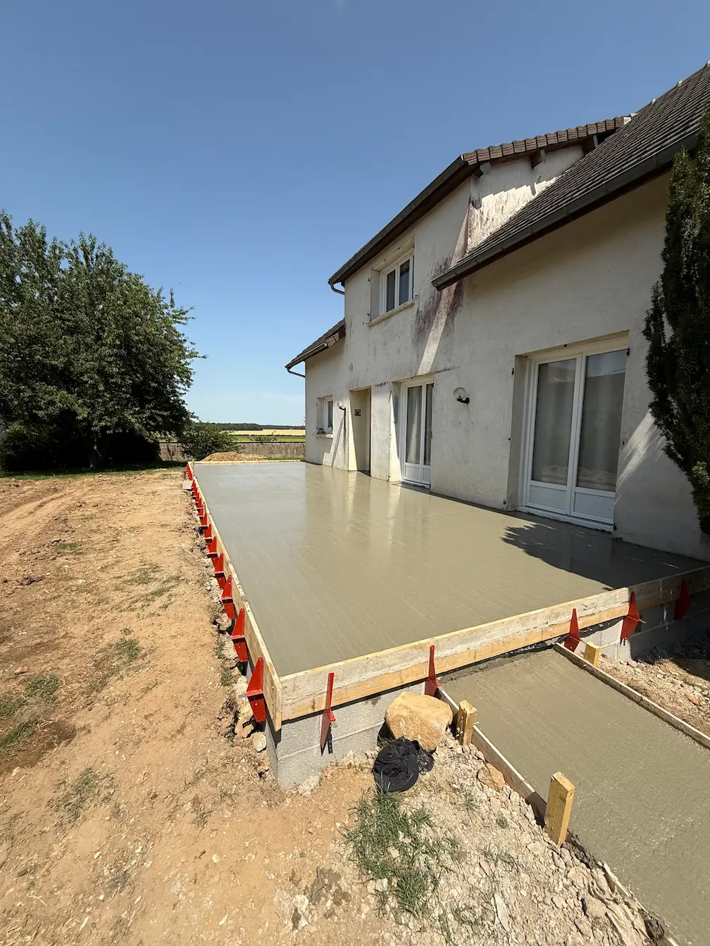 Coulage d'une dalle béton pour terrasse le long d'une maison
