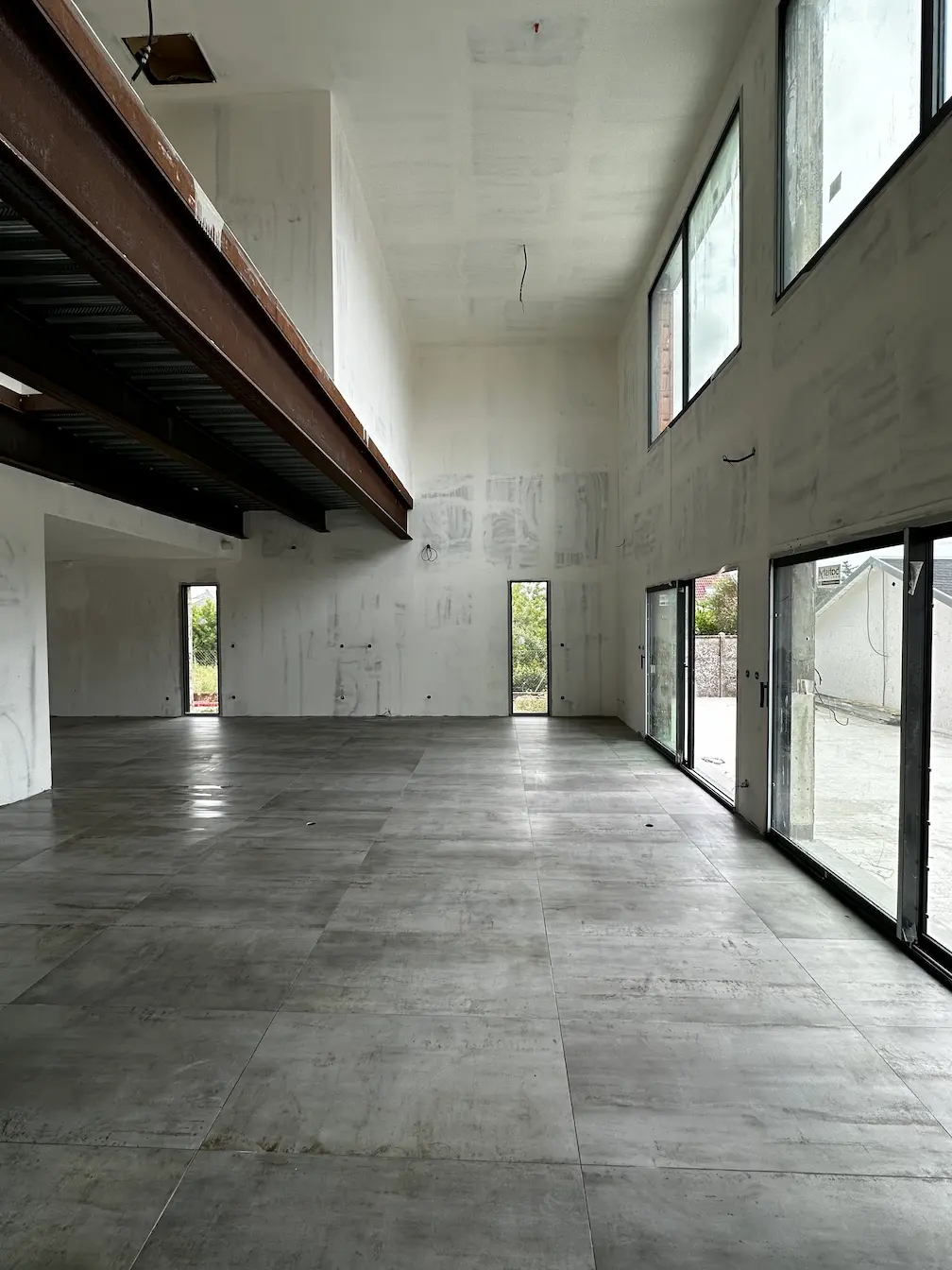 Intérieur moderne avec escalier en béton brut et sol en carrelage grand format