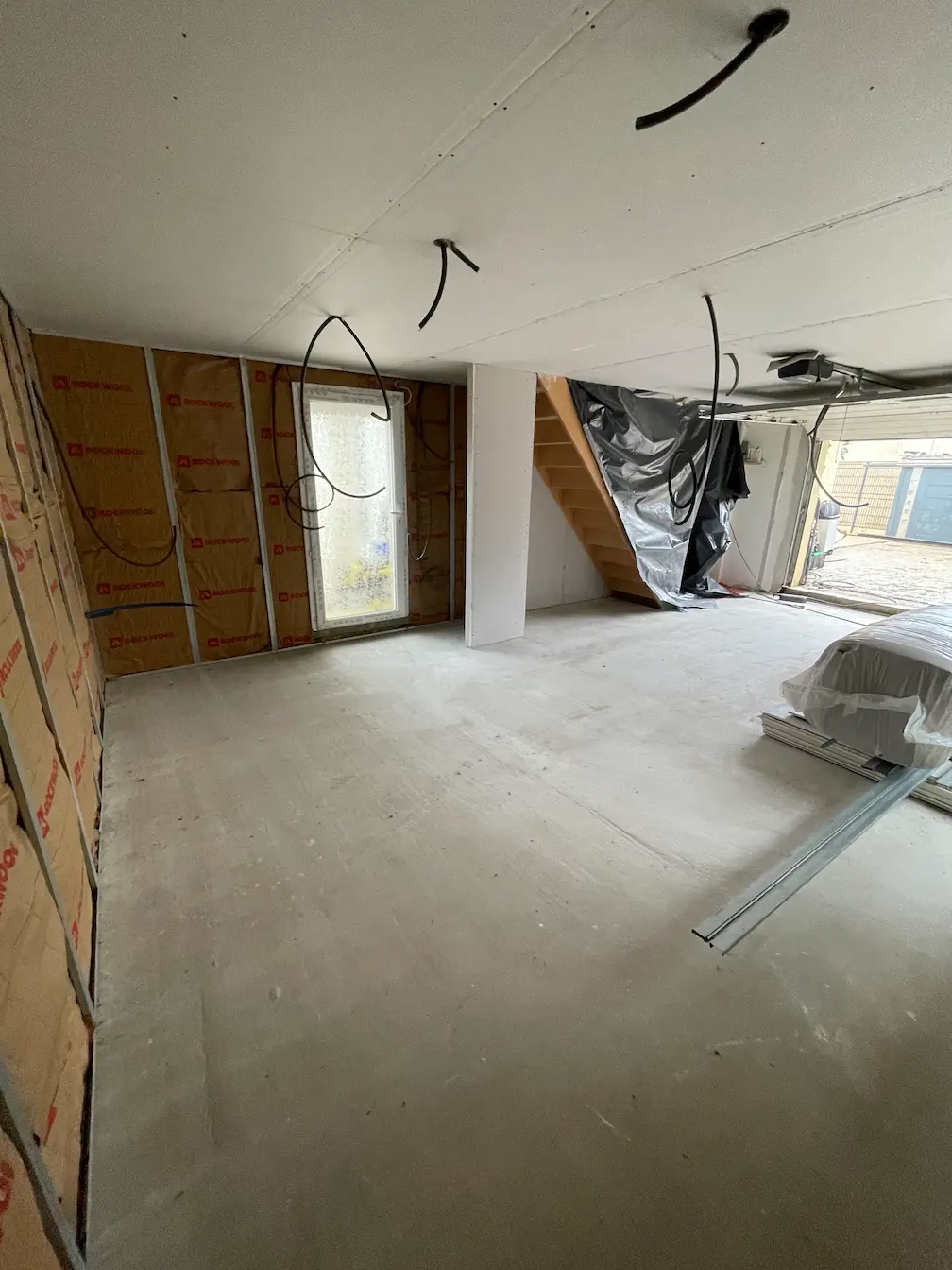 Pièce en cours d'aménagement avec isolation Rockwool, faux plafond et câblage électrique apparent