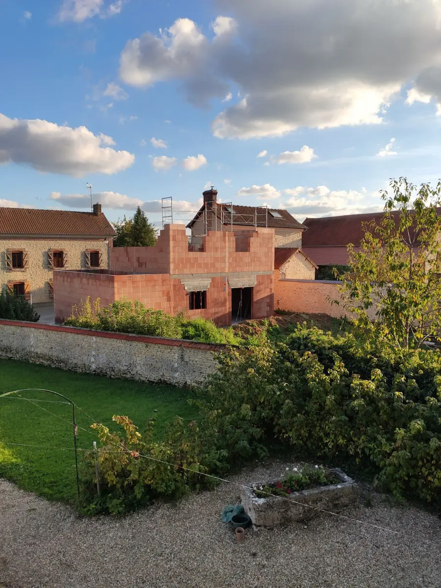 "Construction neuve en briques, vue extérieure avec toiture en cours de finition