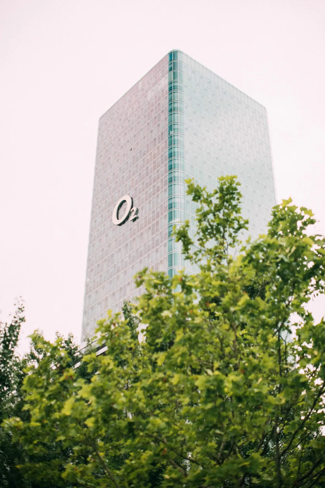 o2 Tower in München, Sitz von Wayra Germany, hinter grünen Bäumen