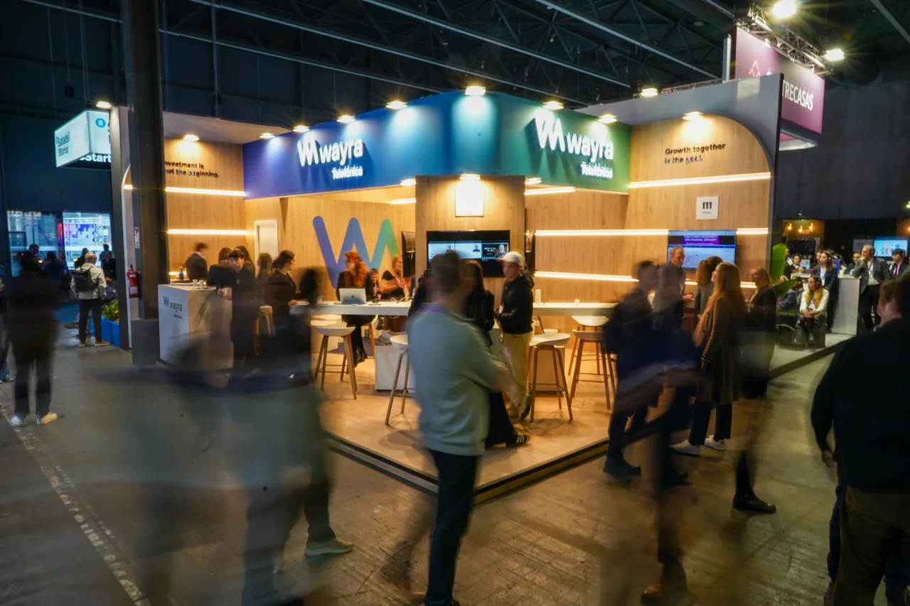 Wayra trade fair booth with visitors at a tech conference