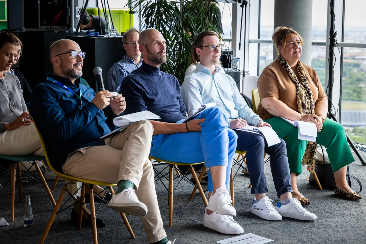 Panel mit sechs Gästen vor Publikum im Wayra-Office