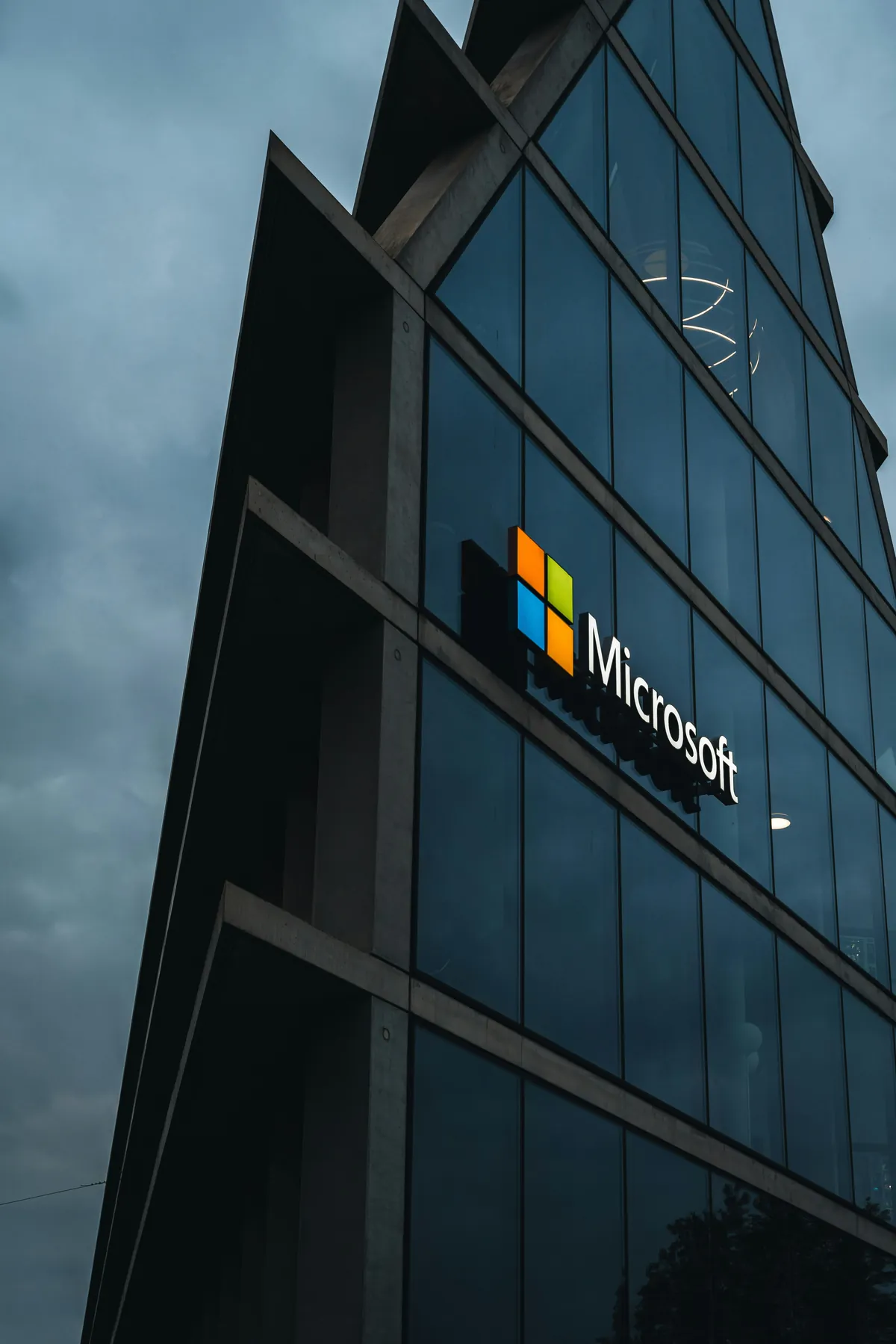 Microsoft logo on the facade of a modern glass office building