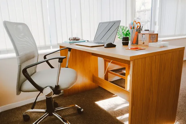 Heller Arbeitsplatz mit Holzschreibtisch, Laptop und Bürostuhl, wie ihn Startups in einem Inkubator nutzen