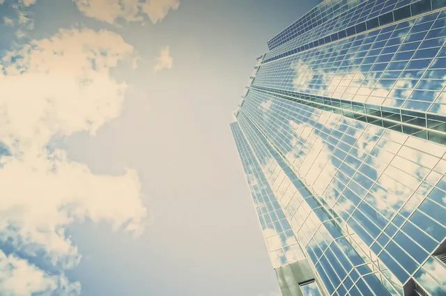 Gläserner Büroturm von unten vor bewölktem Himmel als Sinnbild für den strukturierten Design-Thinking-Prozess