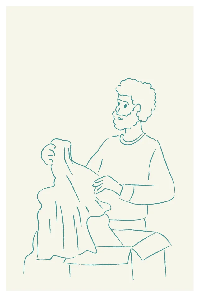 Line drawing of a man with curly hair and a beard holding up a piece of clothing while standing next to an open box.