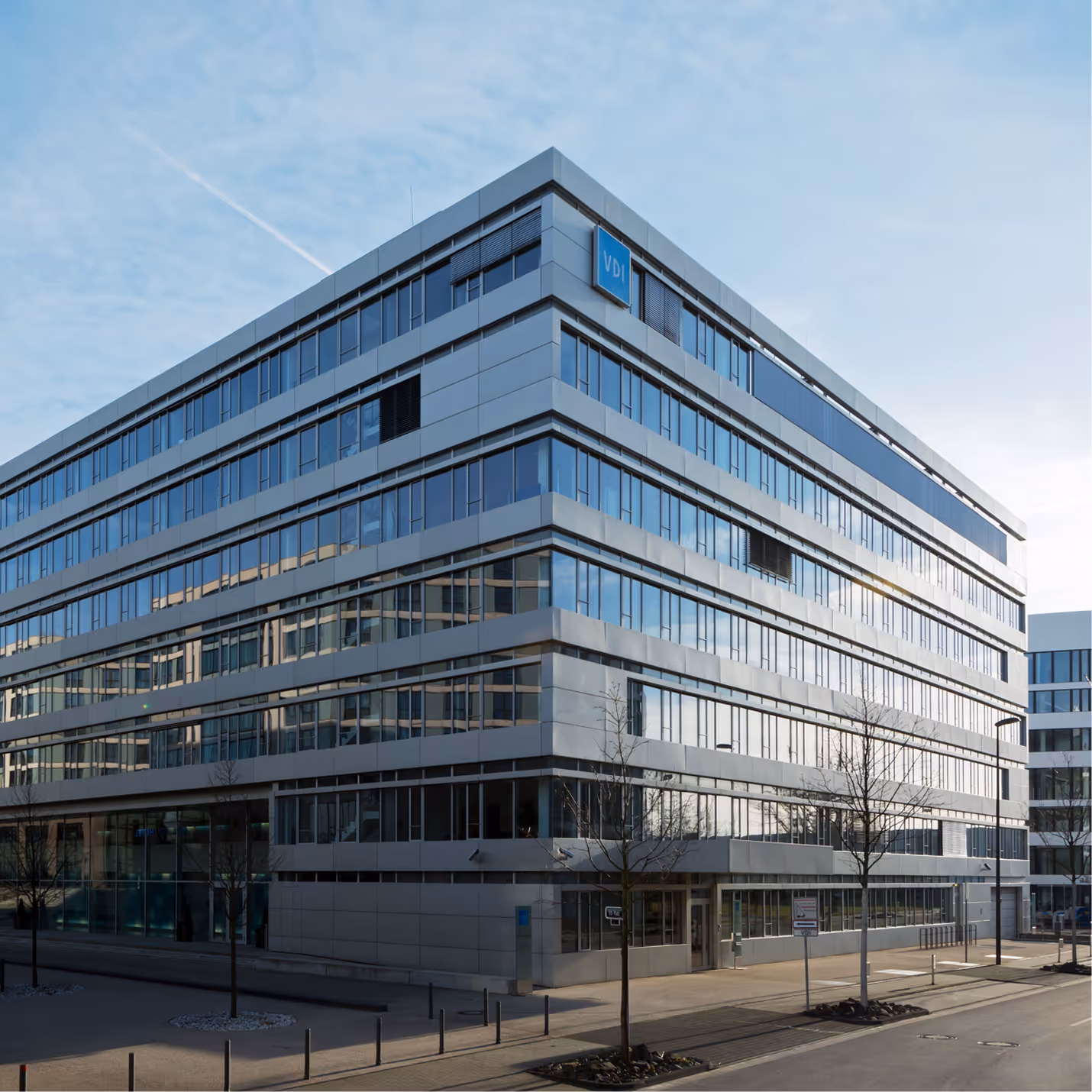 Modernes Bürogebäude mit vielen Fenstern und VDI-Logo in der oberen Ecke.