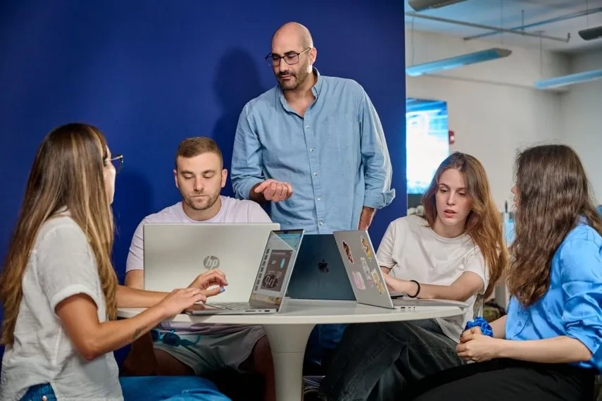Mach9 team working together on laptops.