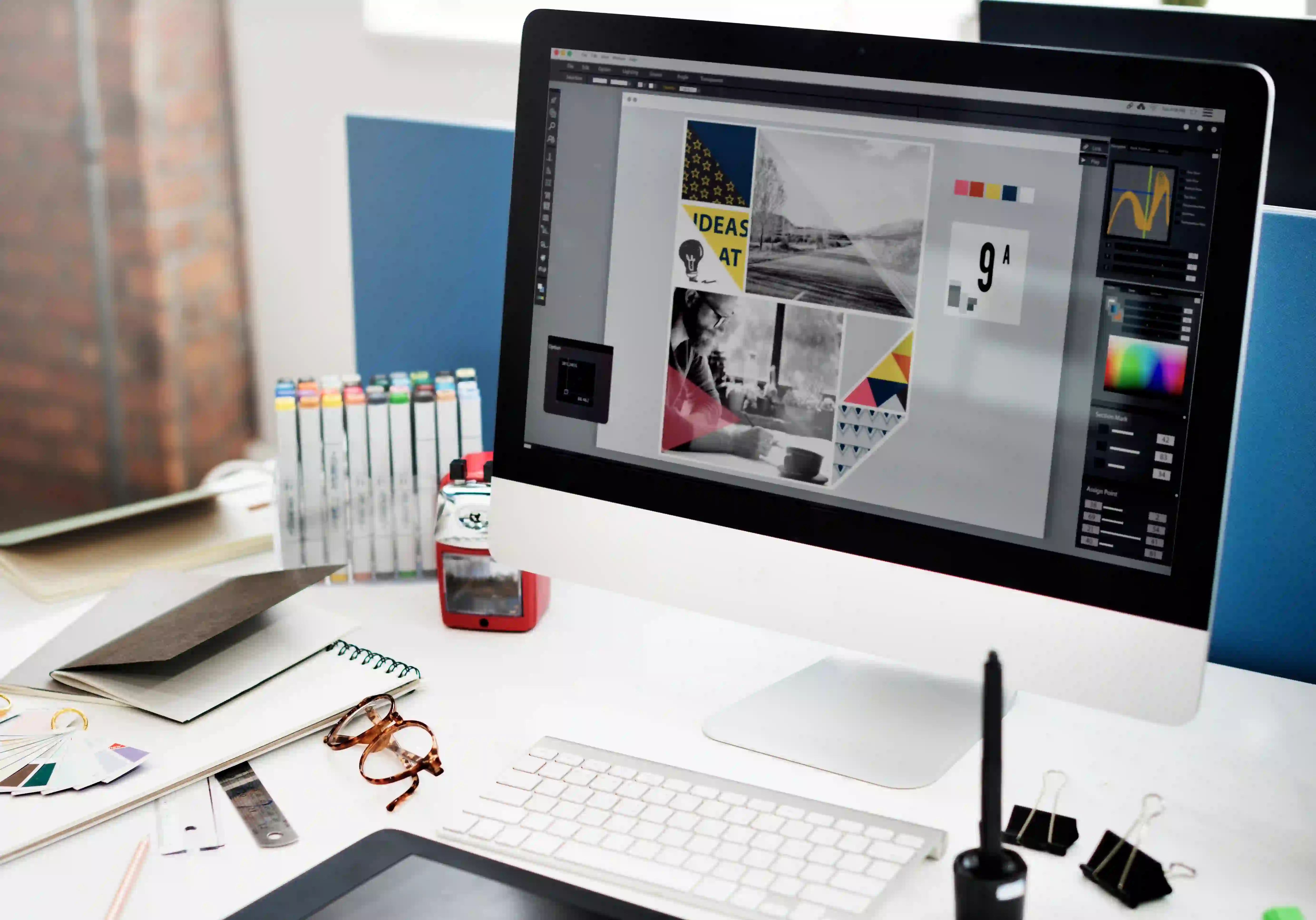 A professional workspace with a monitor displaying visual layouts, representing the structured capabilities of a graphic design agency in India.