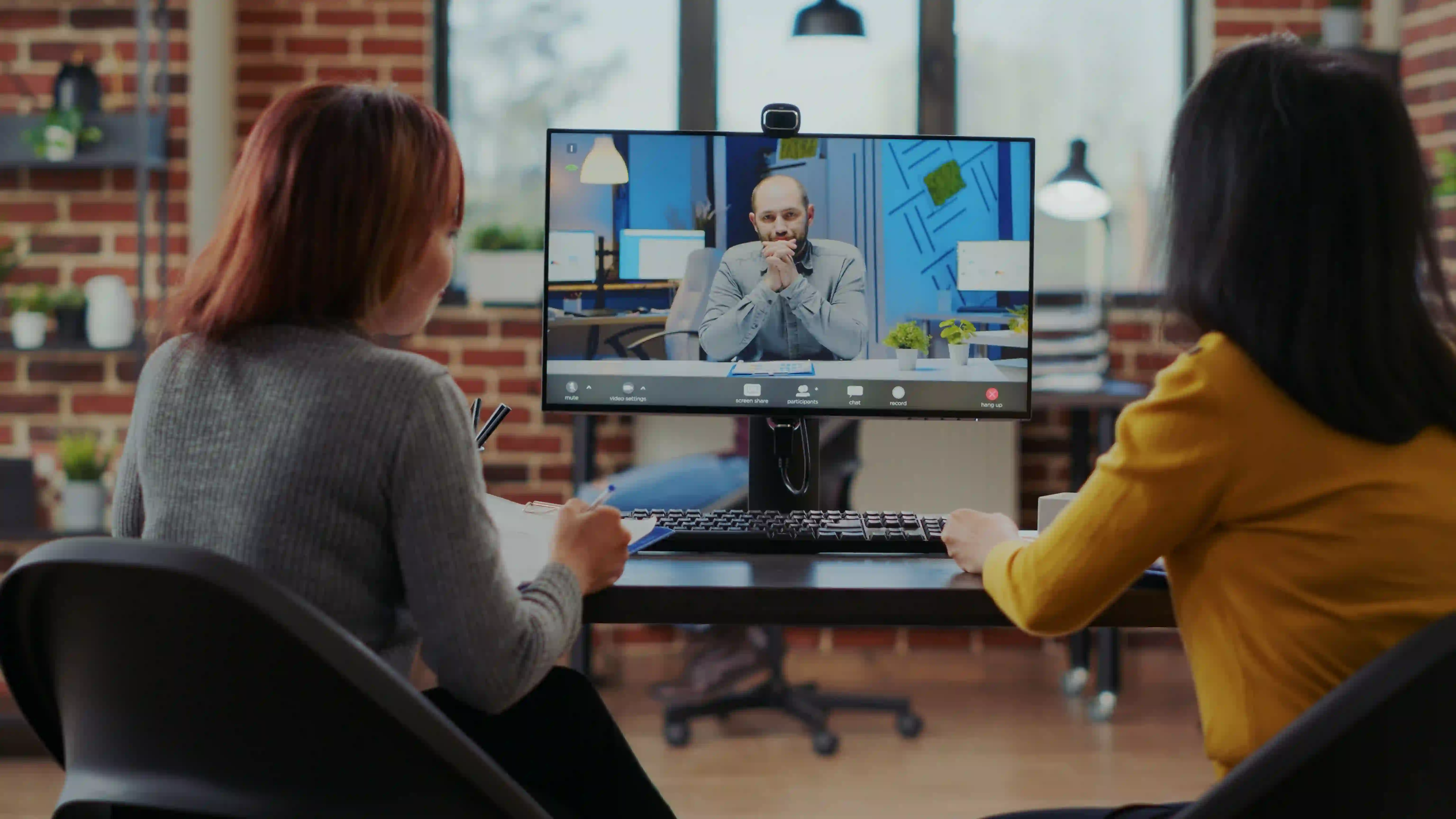 Two marketing professionals on a video conference call, representing the process of evaluating a corporate video partner using an 8-point framework