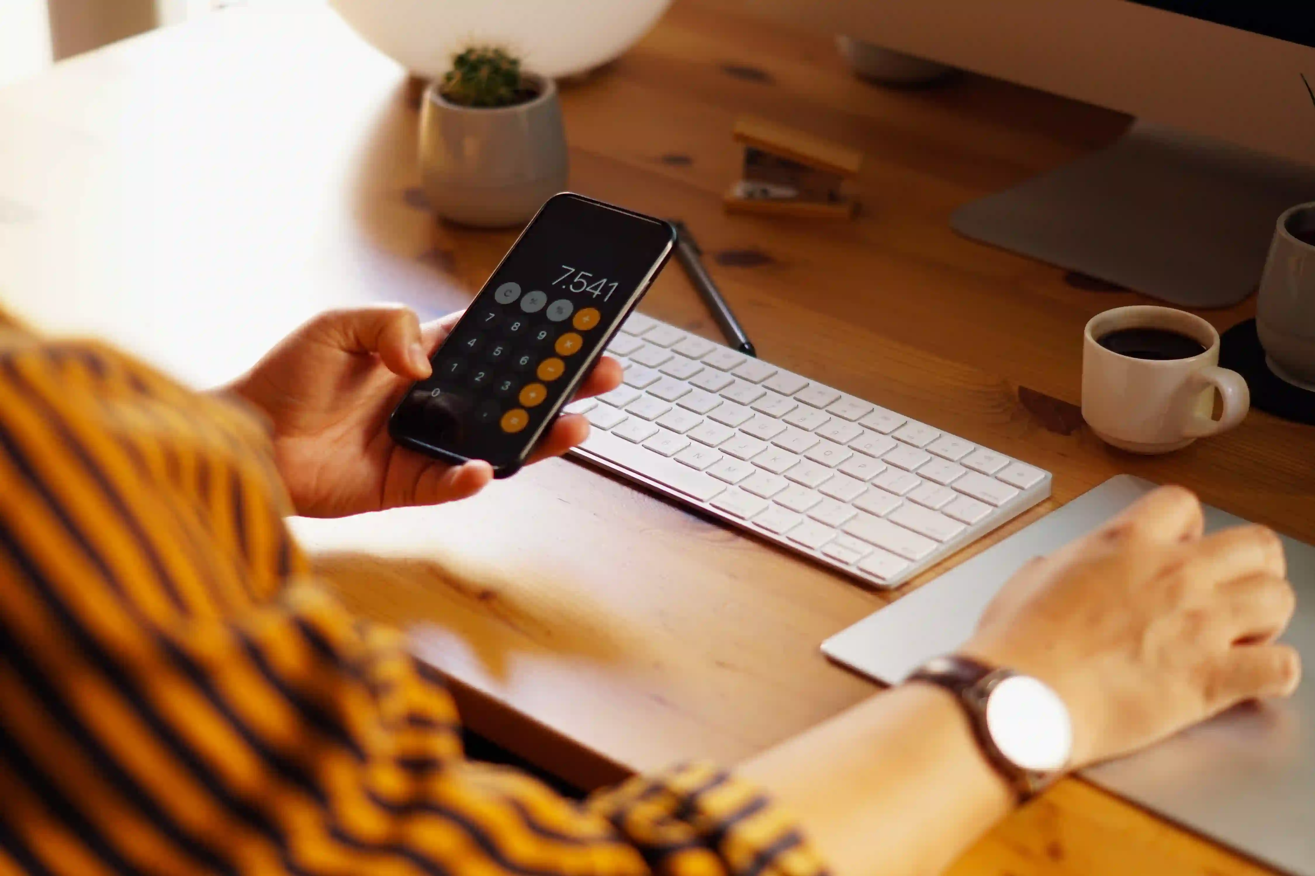 A marketer calculating Annual Contract Value and ICP size on a mobile device to understand what each approach does differently for their pipeline