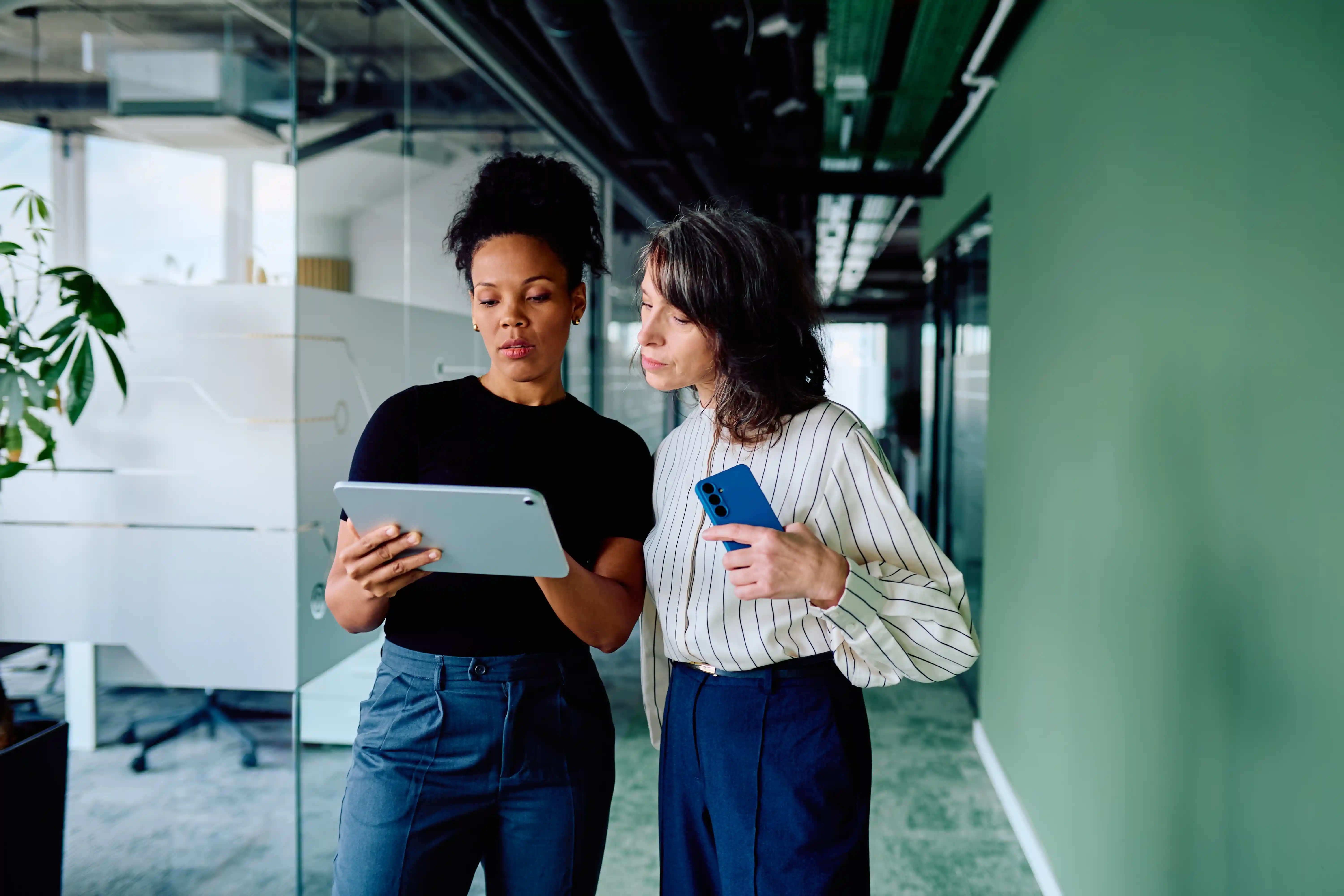 Two enterprise marketers collaborating over data on a tablet, illustrating what an integrated B2B digital marketing function must include in 2027.