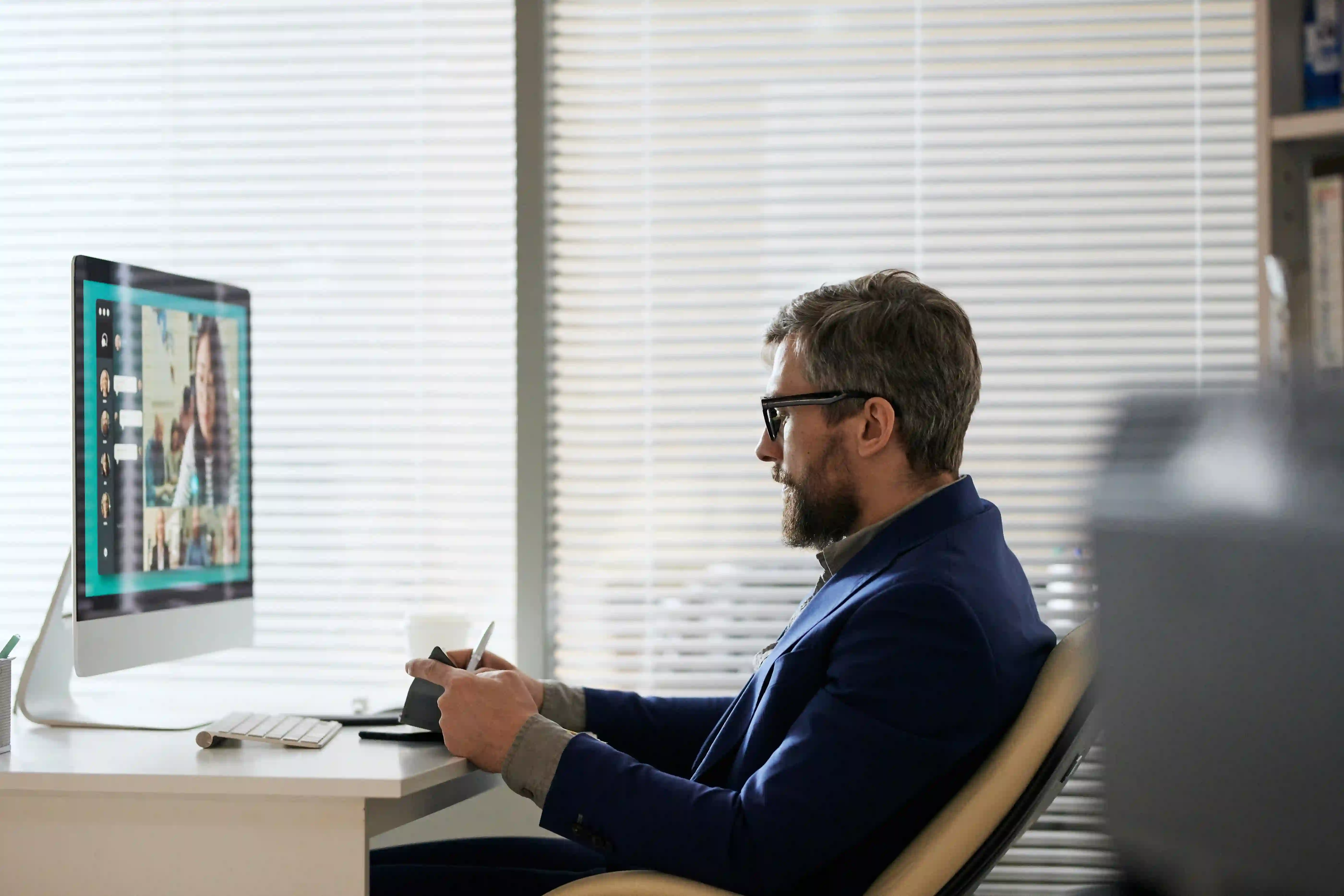 A B2B marketing professional smiling during a meeting, representing the common but misleading feeling of success when focusing on vanity campaign metrics.